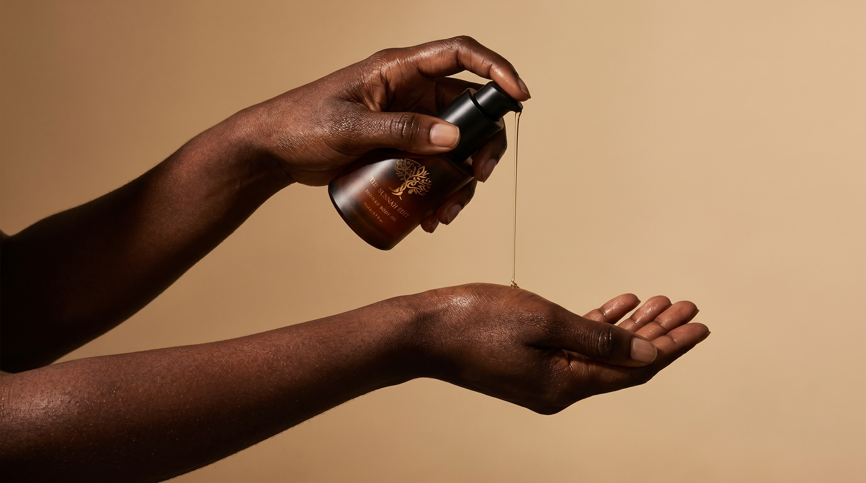 Golden body oil being dispensed onto open hands